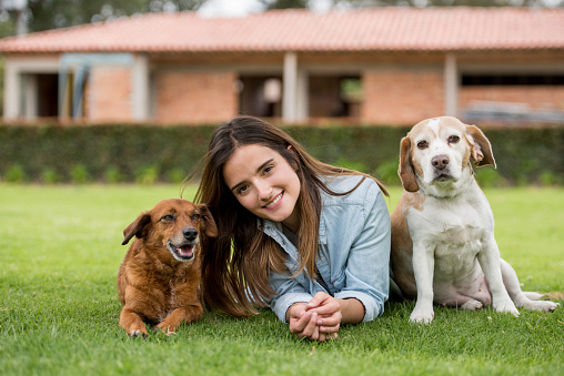 Portrait of a happy woman with her two adopted dogs at the park â lifestyle concepts