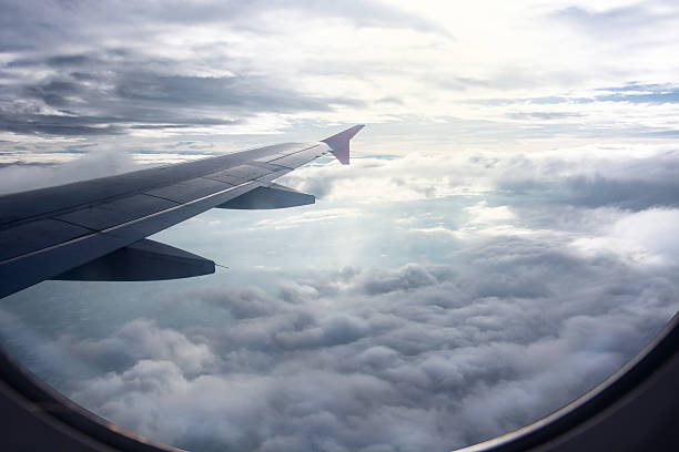 istock View of beautiful raincloud and wing of airplane from window 608004326