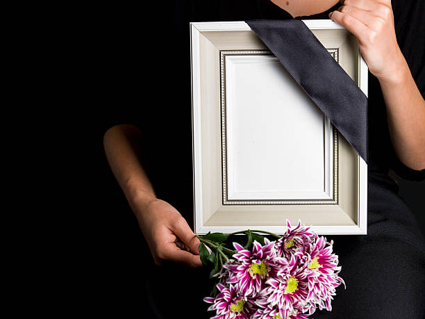 istock woman holds blank mourning frame, with flower 608004448