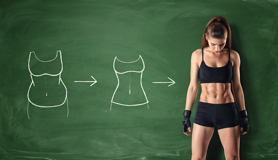 Concept of how a girl's body changing - from fat belly to perfect waist and abs on the background of a chalkboard. Self-improvement and sport. Athletic body. Workout and fitness.