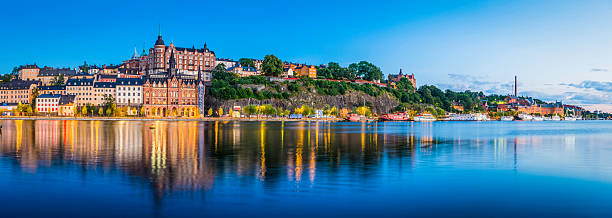 Stockholm dusk twilight illuminating Sodermalm tranquil waterfront Riddarfjarden panorama Sweden The historic townhouses, apartment buildings and boats along the Sodermalm waterfront illuminated by the gentle light of dusk reflecting in the tranquil waters of Riddarfjarden in the heart of Stockholm, Sweden's vibrant capital city. sodermalm photos stock pictures, royalty-free photos & images