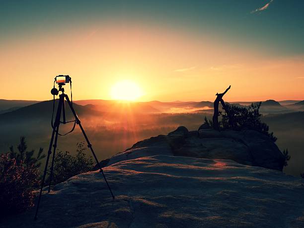 istock Tripod with running camera on rocky peak ready for photography. 608005746