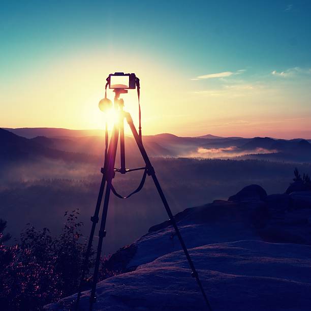 istock Tripod with running camera on rocky peak ready for photography. 608005806