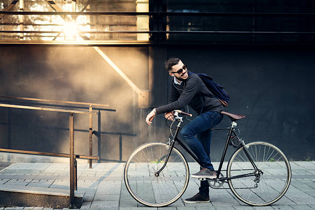 Best city transportation A young stylish businessman going to work by bike. hipster bike stock pictures, royalty-free photos & images