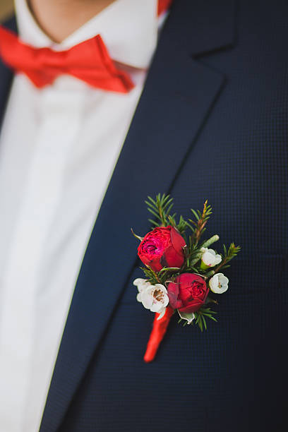 istock Close up of red rose corsage on man suit 608008732