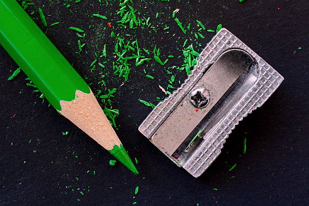 green wooden pencil, pencil shavings and sharpener stock photo