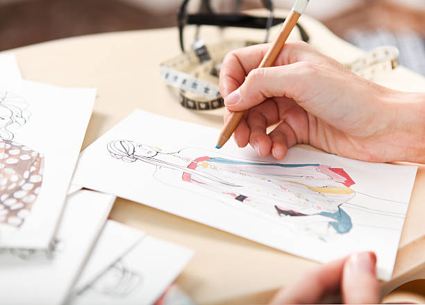 istock Dressmaker is drawing a fashion sketch 608471504