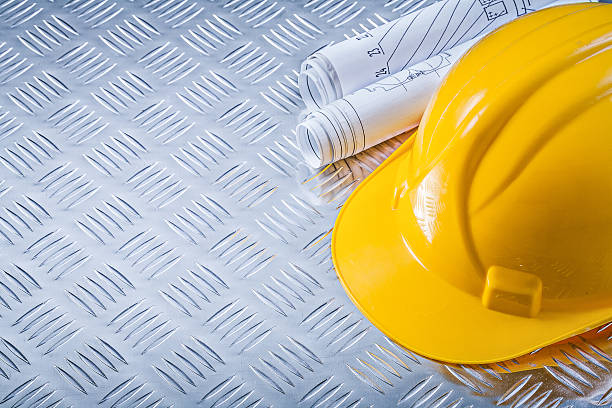 istock Engineering drawings hard hat on fluted metal plate building con 608481968