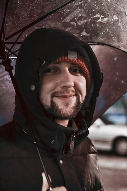 istock Young happy man under umbrella smiling. Bad weather 608489018