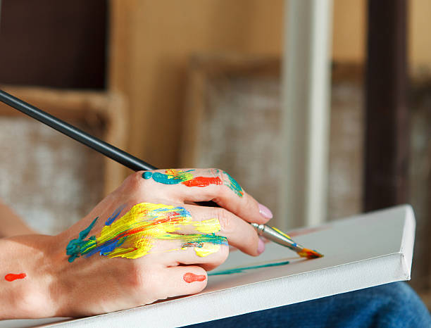 istock Female artist hand holding paintbrush 608489324