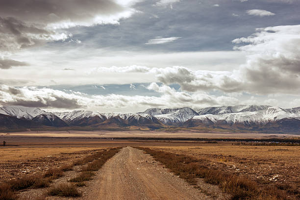 istock Old highway against mountains and a cloudy sky 608505860