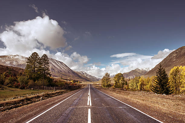 istock Old highway against mountains and a cloudy sky 608505932