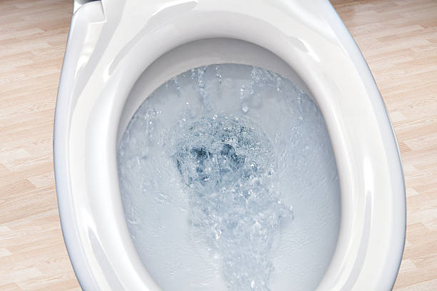 Closeup view of a flushing white toilet bowl. Toilet bowl  flushing water in bathroom close up. flushing toilet stock pictures, royalty-free photos & images