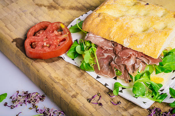 istock Tomato slices with vegetables on a ham sandwich 608508866