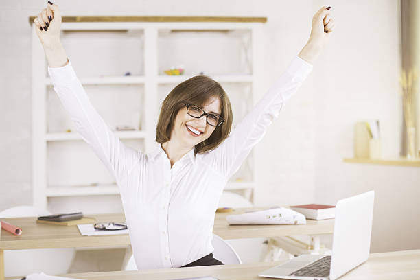 istock Woman celebrating success in office 608514732