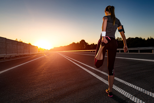 stretching run runner road jogging clothes flare sunset street fitness cross sunbeam success running sportswear - stock image