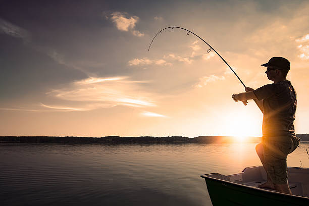 Fishing concepts. fishing rod lake fisherman men sport summer lure sunset water outdoor sunrise fish - stock image fishing tackle stock pictures, royalty-free photos & images