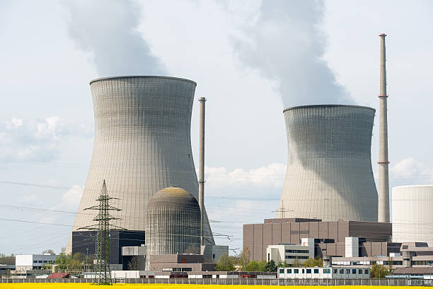 istock Nuclear power plant with yellow field and big blue clouds 608517528