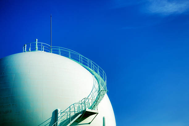 Sphere gas tank top with stairways and blue sky.