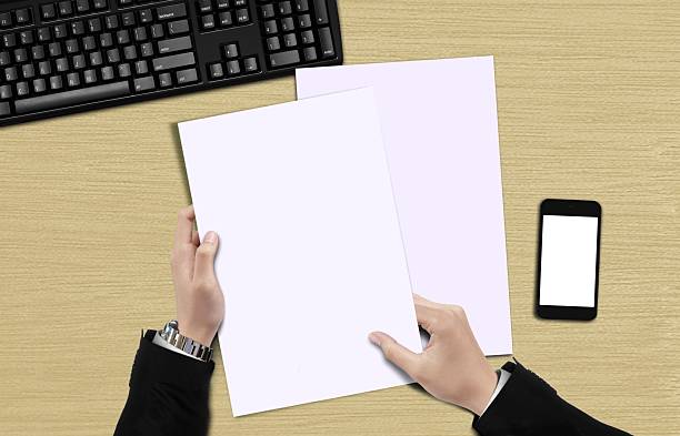 istock Hand holding blank paper top view 608518380