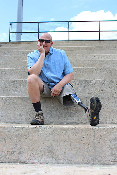 istock Seated amputee man with prosthetic leg outstretched 608523870