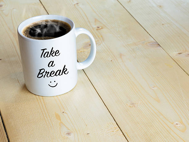 istock Take a break with smiley face on mug wood table 608528618