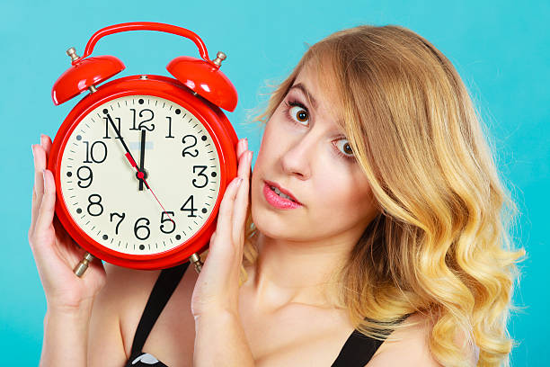 istock Serious girl with alarm clock on blue. 608529236