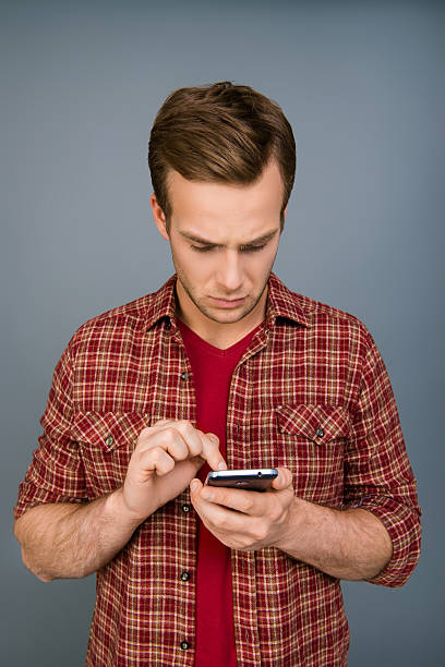 istock Minded serious young man typing message on smartphone 608533028