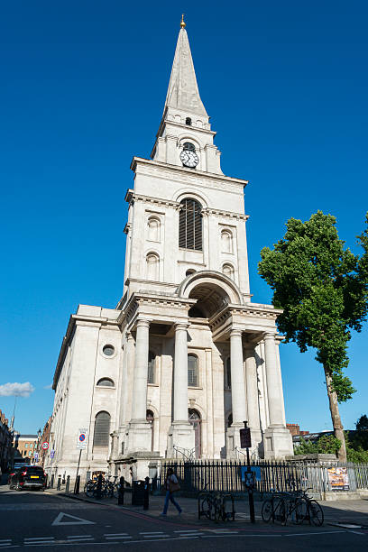 London, United Kingdom - June 20, 2016: People passing the famous Christ Church of Spitalfields in Whitechapel the East End late in the day.