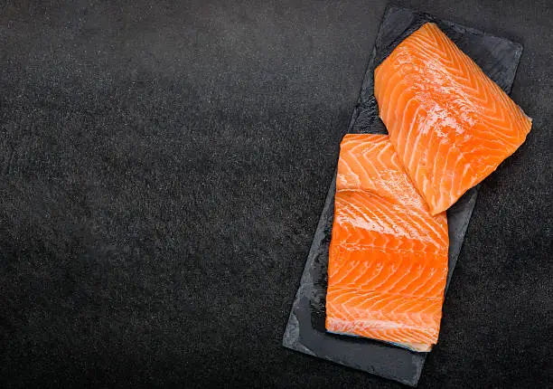 Copy Space with Red Salmon Fillet on dark background