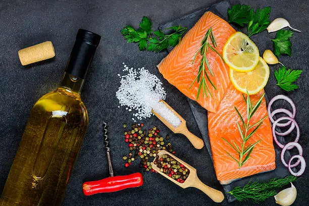 White Wine with Salmon fish Fillet and cooking ingredients, spices, herbs and seasoning.