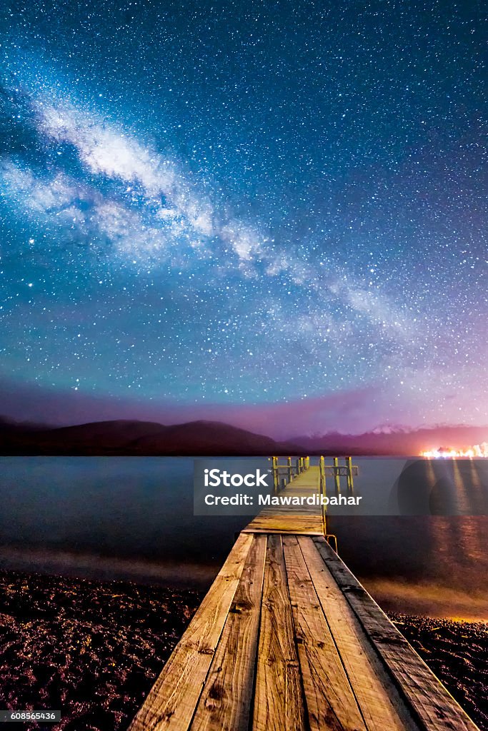 Milkyway with wooden jetty Night milkyway with wooden jetty at Te Anau, New ZealandNight milkyway with wooden jetty at Te Anau, New Zealand Beach Stock Photo