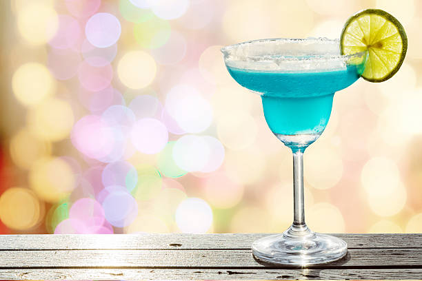 istock Blue cocktail on  blurred bokeh light in warm tone background 608573460