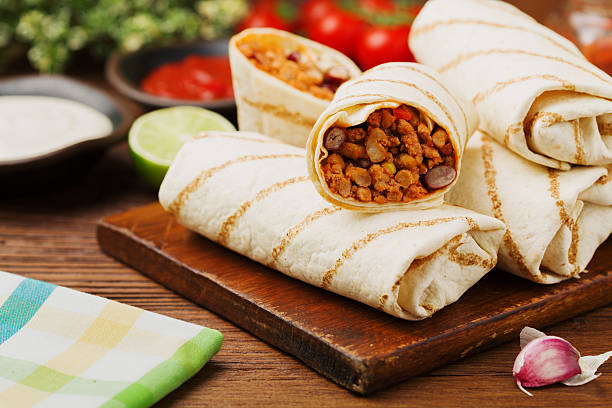 istock Burritos wraps with meat, beans and vegetables. 608584090