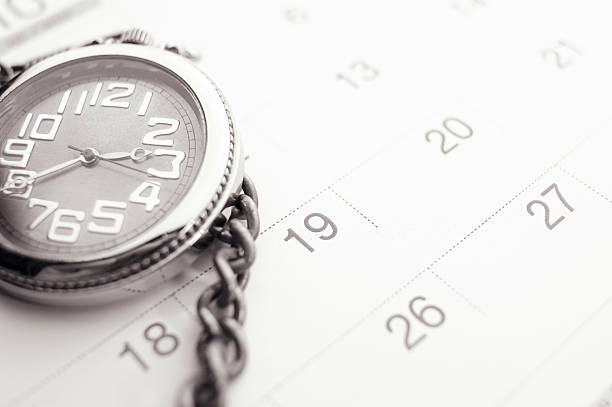 istock Old pocket watch on calendar page. vintage, black&white 608589970