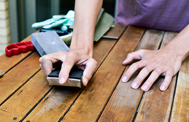 istock young man sanding a wooden table with a sanding block 608590238