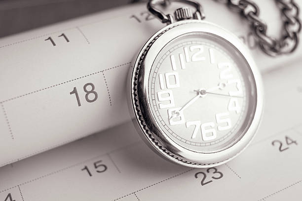 istock Old pocket watch on calendar page. vintage, black&white 608591256
