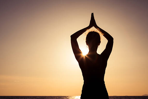 istock woman open arms under the sunset at sea. 608593874