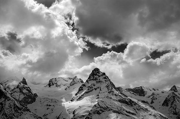 istock Black and white view on evening mountains in sunlight clouds 608594566