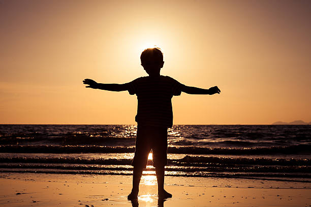 istock Happy little boy standing on the beach 608596284