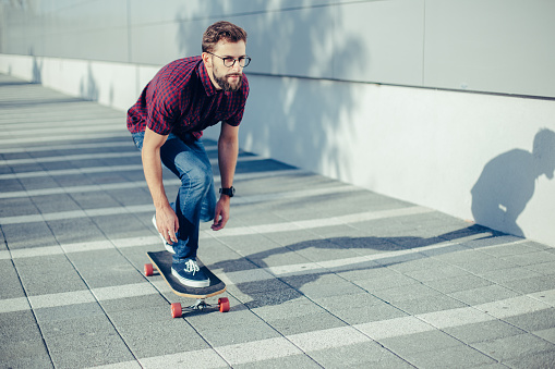 Young hipster riding skateboard.