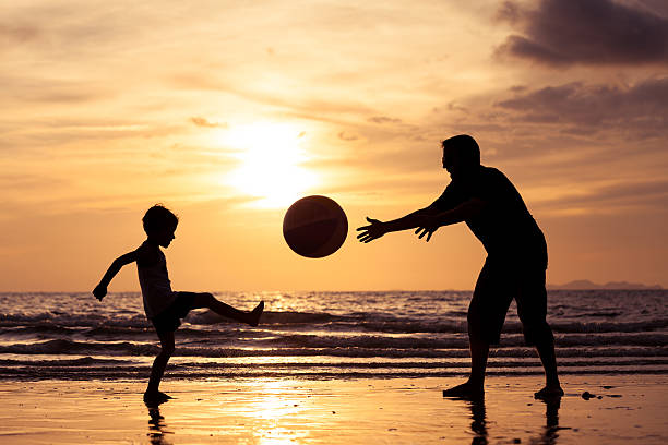 istock Father and son playing on the beach at the sunset. 608615206