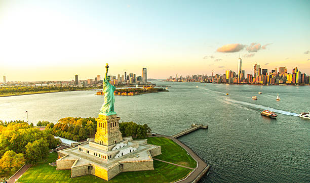 liberty island con vistas al horizonte de manhattan - statue of liberty new york city statue usa fotografías e imágenes de stock