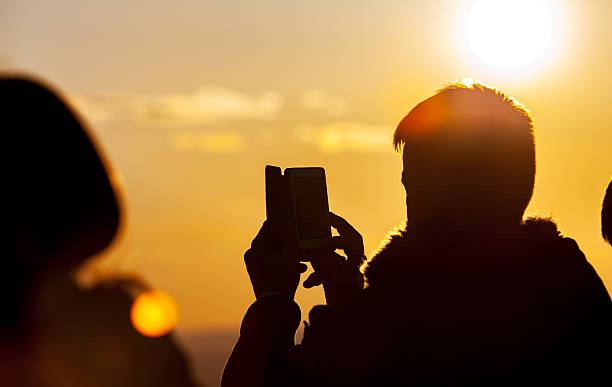 istock Taking photos of sunset with mobile phone 608619008