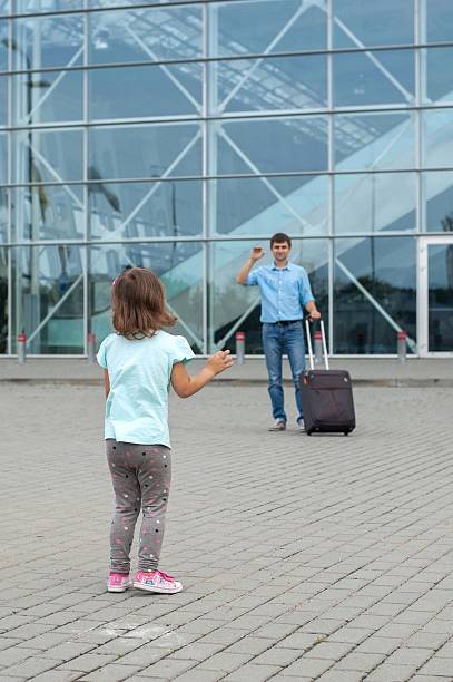 child says goodbye to the dad at the airport - separation airport child waving imagens e fotografias de stock