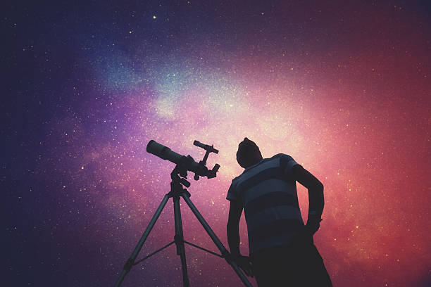 l’homme regardant les étoiles avec un télescope à côté de lui. - astrolabe photos et images de collection