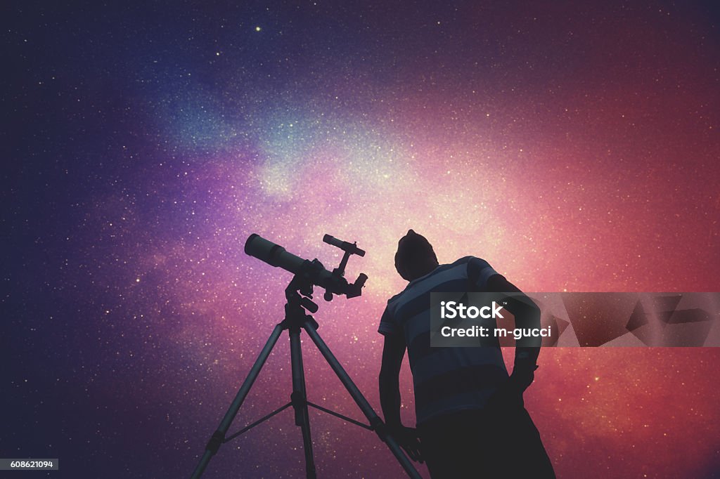 Man looking at the stars with telescope beside him. Man looking at the stars with telescope beside him. Milky Way stars are my astronomy work, no elements of NASA or other third party. Astronomy Stock Photo