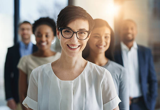 Driving the company forward with impeccable team leadership Cropped shot of a group of businesspeople standing in the office group of people wearing eyeglasses stock pictures, royalty-free photos & images