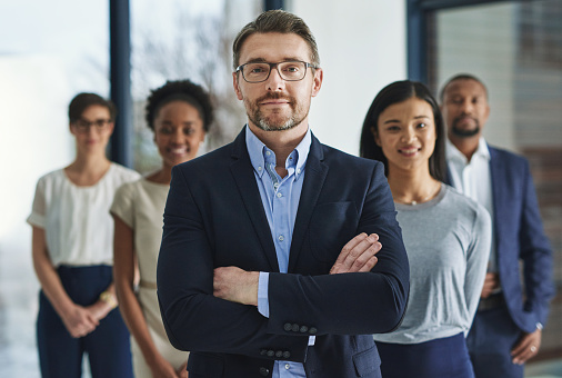 Cropped shot of a group of businesspeople standing in the office