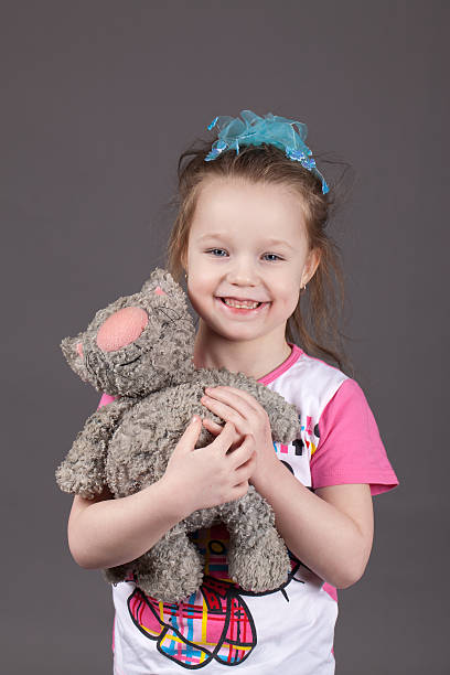istock Little girl holding a toy cat 608638274